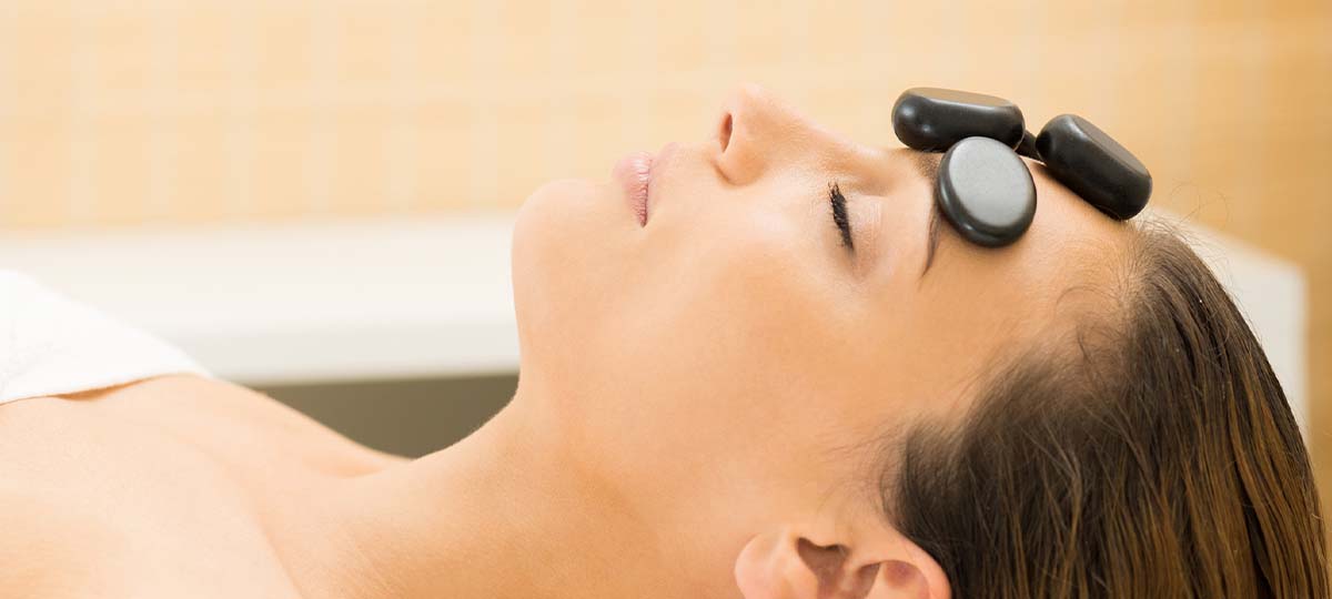 Woman lying supine with stones on her face