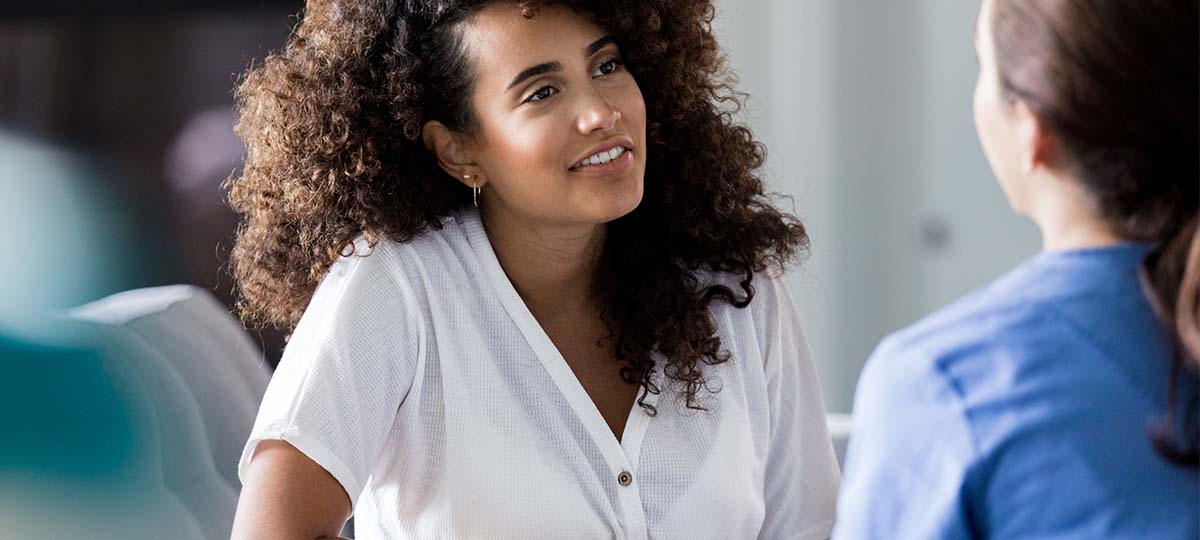 Woman with elbow on table talking to another person