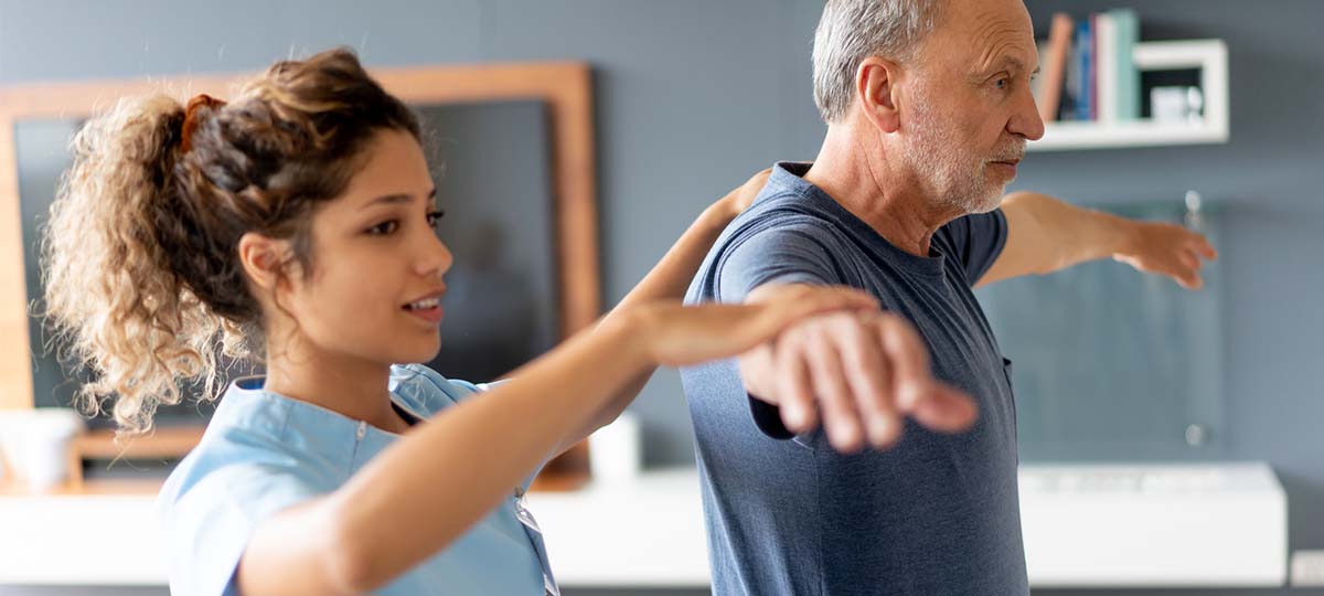 Massage therapists working with person with their arms out at their sides